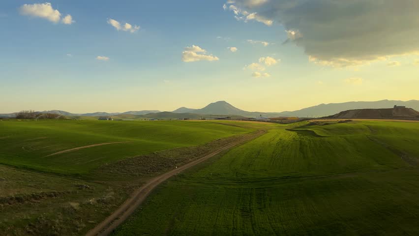 green hills landscape aerial scenic panoramic sunset mountain road trip Train Kurdistan Azerbaijan blue sky rural countryside yellow canola fields blooming agriculture sustainable farming Trip to Iran
