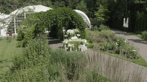 Aerial View of Elegant Outdoor Event Setup Under Green Arch