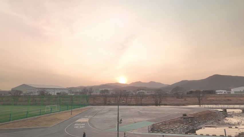 Timelapse of winter sunset over Tancheon stream in Seongnam, South Korea. Evening light gradually changing across the sky above the urban riverside landscape.