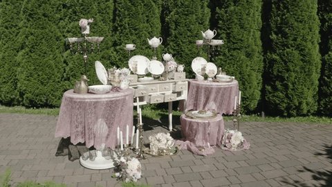 Elegant Outdoor Tableware Display with Floral Accents in Lush Garden