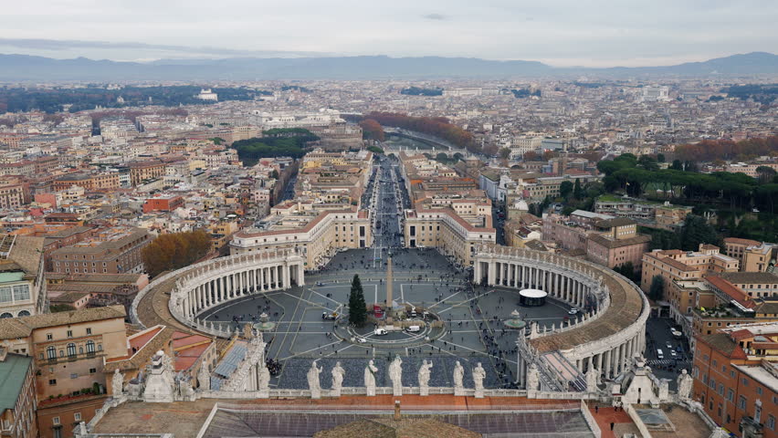 Aerial view of St. Peter’s Square and Via della Conciliazione leading into Rome, with the iconic colonnades, obelisk and surrounding cityscape. Majestic landmark, travel and religion destination.