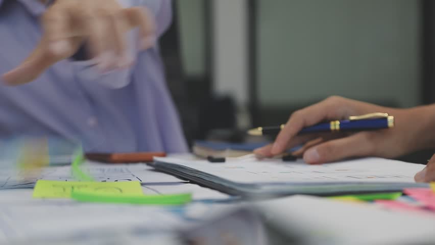 Team of uxui designers pointing at computer screen, discussing new mobile app design in the office
