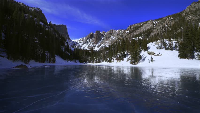 Winter frozen ice Dream Lake Rocky Mountain National Park RMNP Colorado sunny bluesky Hallett Peak Flattop Mountains Tyndall Glacier morning landscape high alpine Emerald Lake Bear Lake trail pan left