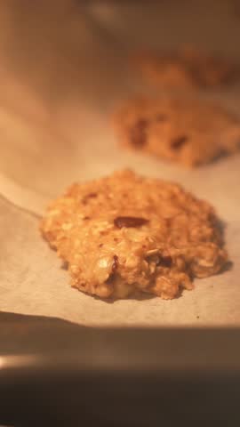 A cookie is baking in the oven. The cookie is made of oats and nuts. The oven is set to 350 degrees