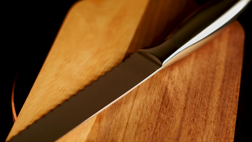Sharp knife resting on wooden cutting board for meal preparation at home kitchen