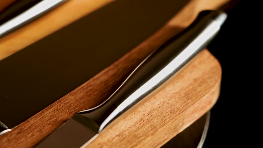 Kitchen knives on a wooden cutting board with different shapes and sizes shown clearly