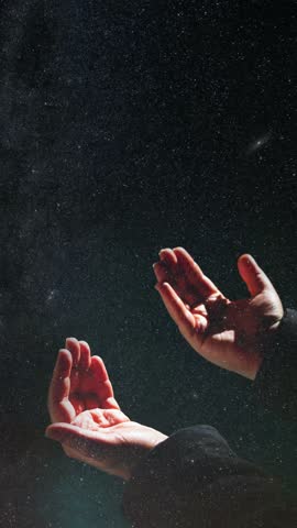 Ramadan or islamic concept vertical video. Praying hands and milky way. Laylat al-qadr or kadir gecesi background.