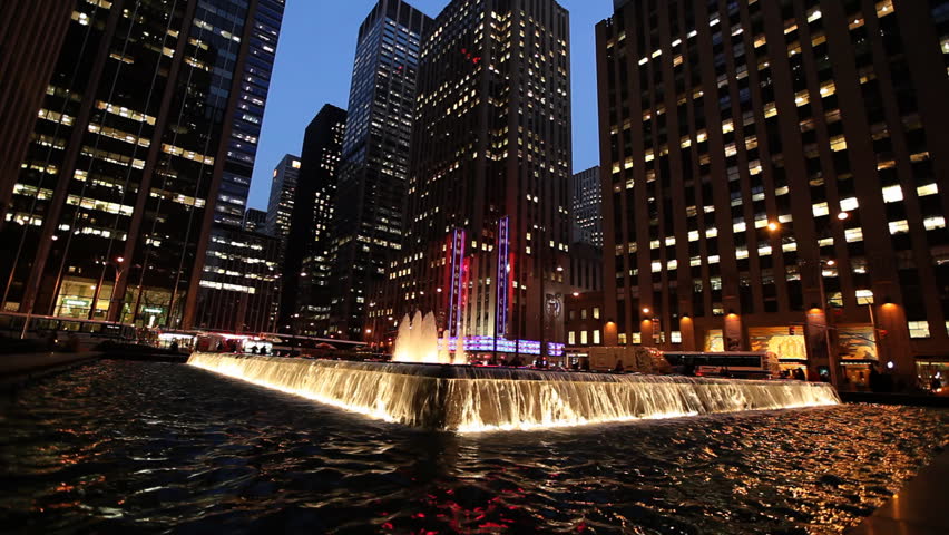 Illuminated water fountain in front of skyscrapers and Radio City Hall in