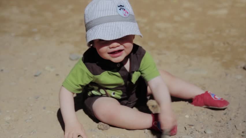 A little baby boy playing in the desert sand