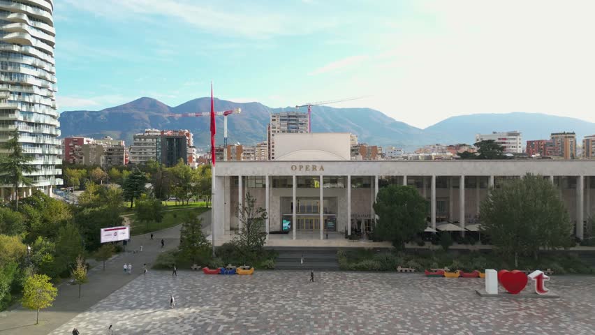 Aerial view of the National Opera Building in Tirana, Albania, showcasing its architecture and surrounding city square.