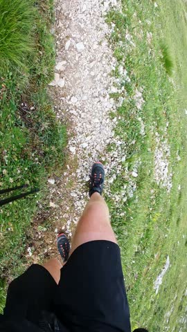 POV of man walking Dolomites trail and looking at massive mountain scenery