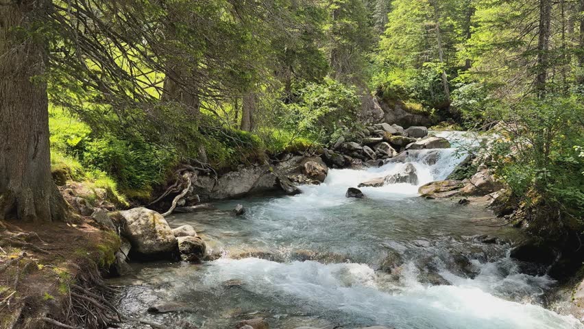 Experience the captivating beauty of a powerful waterfall in slow motion, located within the stunning Austrian Alps near Koenigsleiten. Crystal clear water cascades over rocks, creating a serene and fresh summer scene in the Salzachgeier mountains. (Ultra HD)