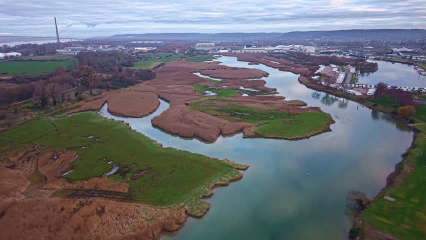 Wetlands and estuary of Bassin Carnot with the Pont de Normandie near Honfleur, France. Aerial forward