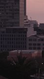 Vertical video: Dusk light hitting tower, gold columns moving and fading, forming warm glow, shadow. Cityscape, skyline, highrise, facade, glass, sunset, vertical video - Powered by Shutterstock - Get 15% off with code: PIKWIZARD15