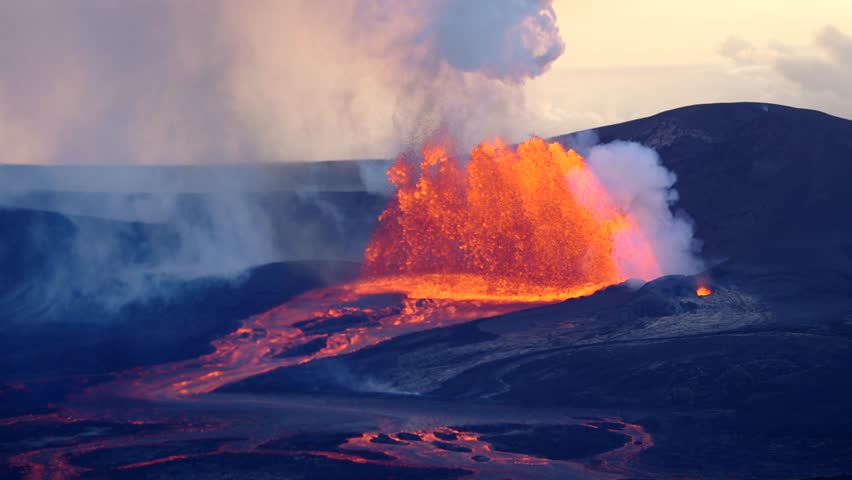 Distant view of a powerful volcano erupting in slow motion with towering lava and smoke rising into the sky.