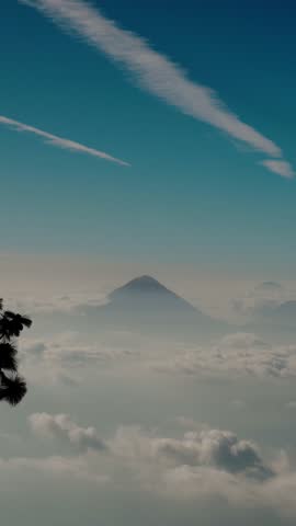 view of Agua Volcano rising above dense cloud layer in Guatemala