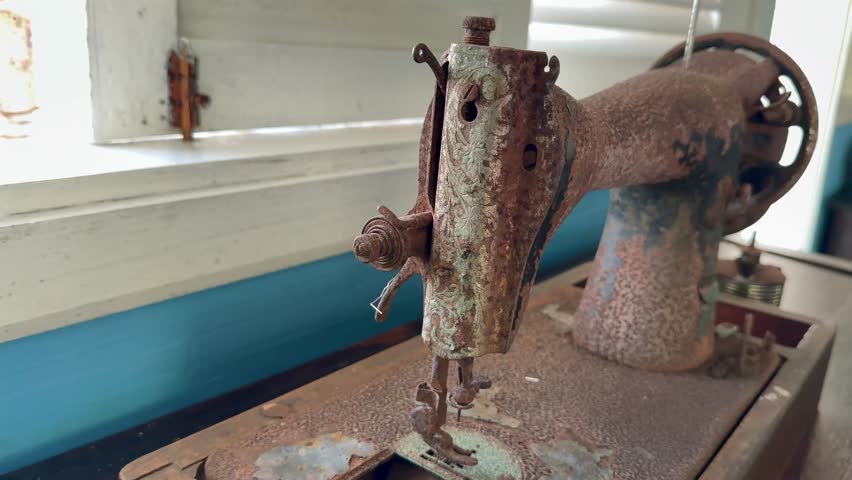 Slow motion of very old rusty singer sewing machine inside colonial house build around 1870