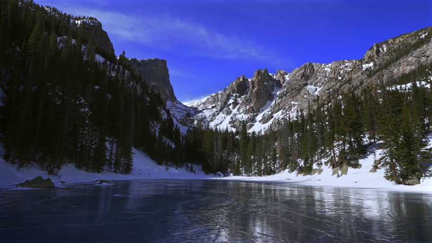 Dream Lake frozen iced over Winter Rocky Mountain National Park RMNP Colorado sunny blue sky Hallett Peak Flattop Mountains Tyndall Glacier morning landscape high alpine Emerald Lake Bear Lake trail