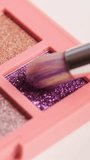 Make-up artist picks up pink pigment from bright colorful eyeshadow palette with a brush. Decorative cosmetics and visage concept. - Powered by Shutterstock - Get 15% off with code: PIKWIZARD15