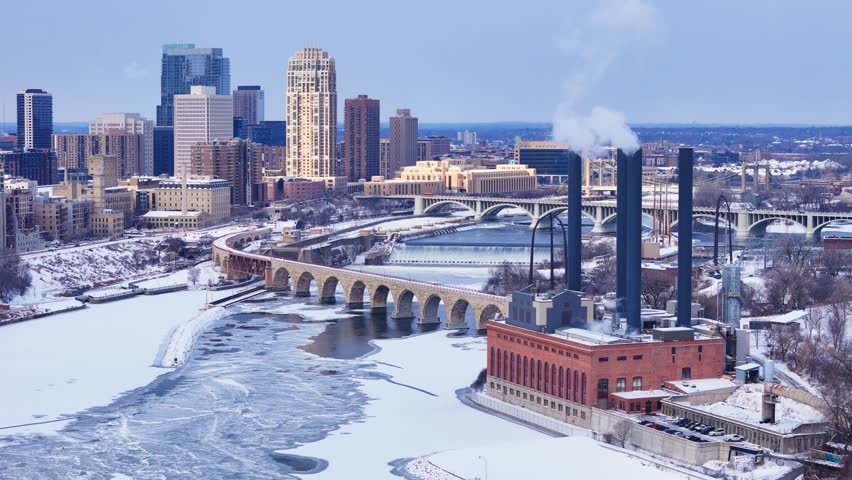 Minneapolis downtown with the Mississippi river and a steam plant, aerial view in winter with 3rd Ave bridge in background