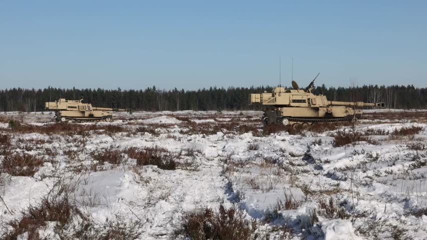 U.S. Army Soldiers prepare Paladin artillery in a snowy field.