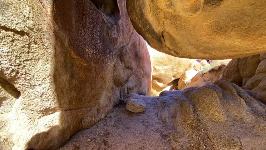 🏜️ Desert Wonders: Scenic Rock Formations in Joshua Tree. Smooth cinematic reveal of unique rounded rock formations and boulders in Joshua Tree National Park. Desert vegetation under a bright sun and blue sky. Atmosphere of unforgettable adventure.