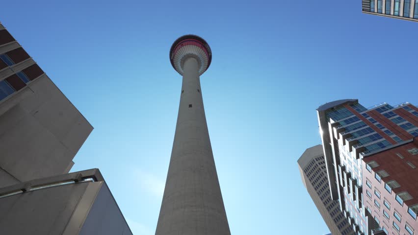 Calgary Tower landmark soaring above surrounding buildings against clear blue sky