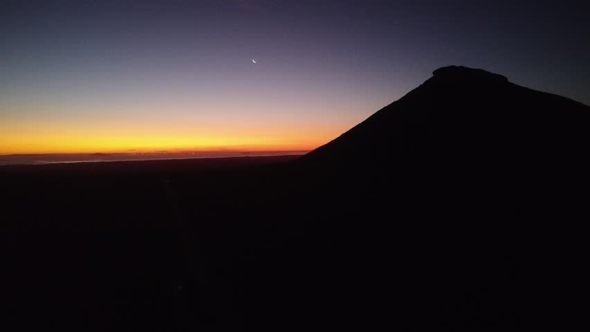 Cinematic drone footage captured during blue hour over Cape Le Grand National Park, Western Australia. Frenchman Peak visible against a deep twilight sky, creating a dramatic and atmospheric coastal landscape in low light conditions.