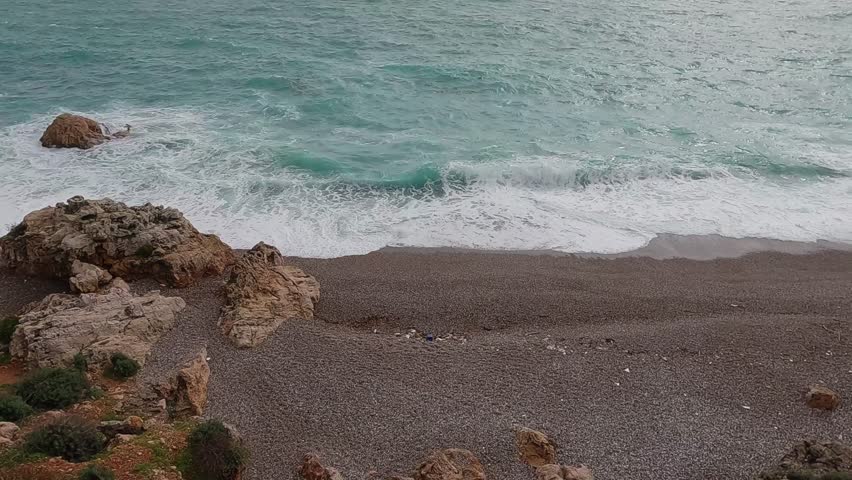 powerful sea waves crashing against rocks on the shore