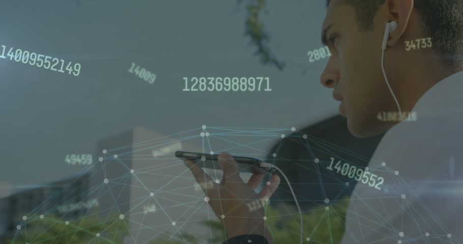 A man is talking on his mobile phone while walking down the street.