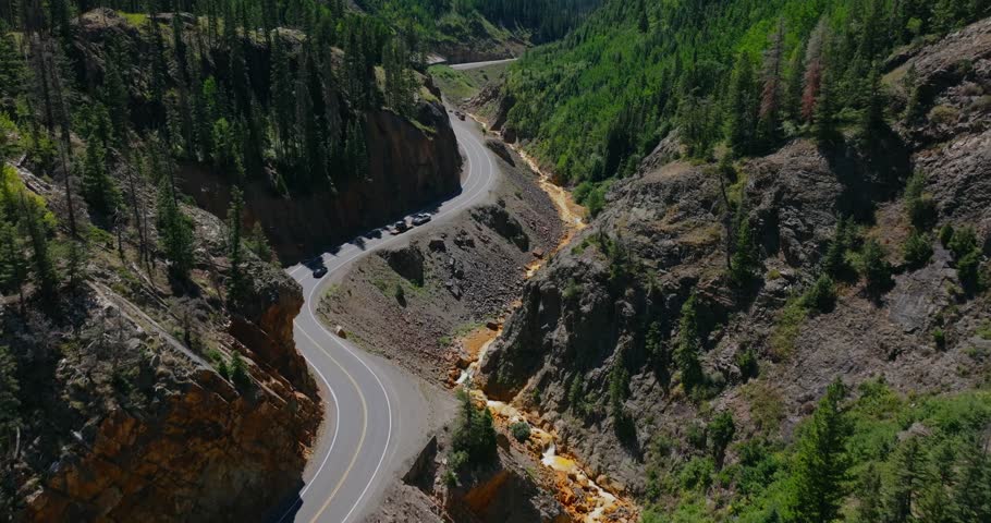 High angle aerial of narrow mountain highway hugging steep canyon walls in Colorado, Million Dollay Highway Colorado USA