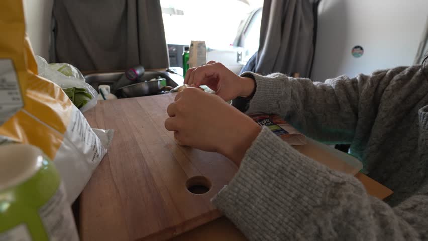 Timelapse of woman preparing fresh bagel sandwiches with vegetables inside a camper van