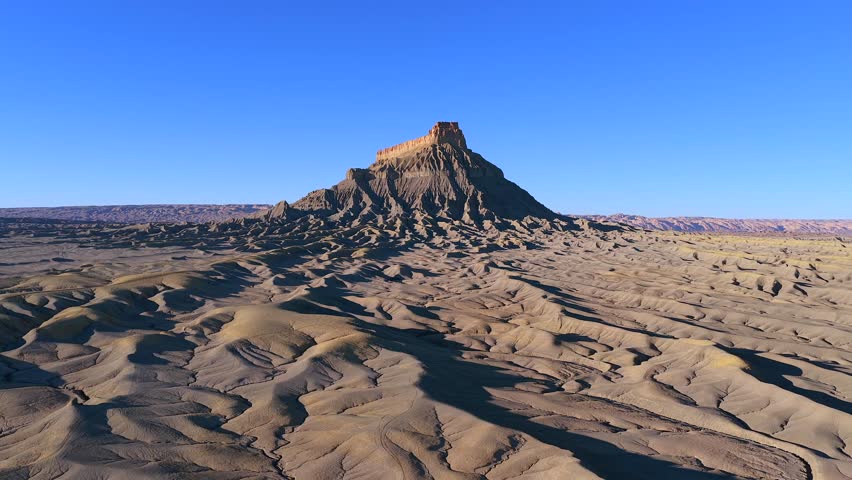 A smooth lateral drone strafe reveals the stark, moon-like ridges of Factory Butte, Utah. This 4K landscape offers a perfect universal backdrop for alien worlds or extraterrestrial planets.