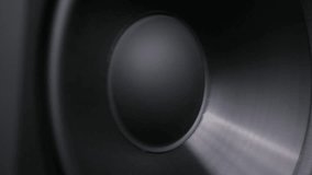 Macro perspective of a black subwoofer diaphragm vibrating intensely from low-frequency bass. The close-up reveals membrane texture and dynamic motion in a studio. - Powered by Shutterstock - Get 15% off with code: PIKWIZARD15