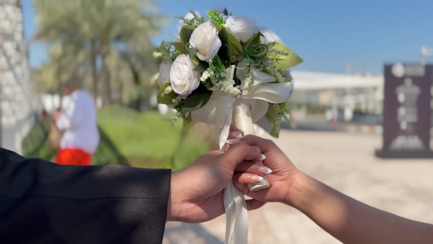 A joyful couple celebrates their honeymoon at the stunning , holding a flower in a romantic moment.