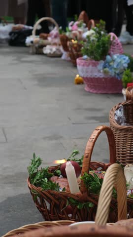 Easter holiday Festive wicker baskets with flowers and candle on pavement