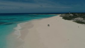 Aerial view of a couple walking holding hands on the white sand beach of Cayo de Agua in the Los Roques Archipelago, Venezuela, with turquoise Caribbean waters and a tropical paradise setting - Powered by Shutterstock - Get 15% off with code: PIKWIZARD15