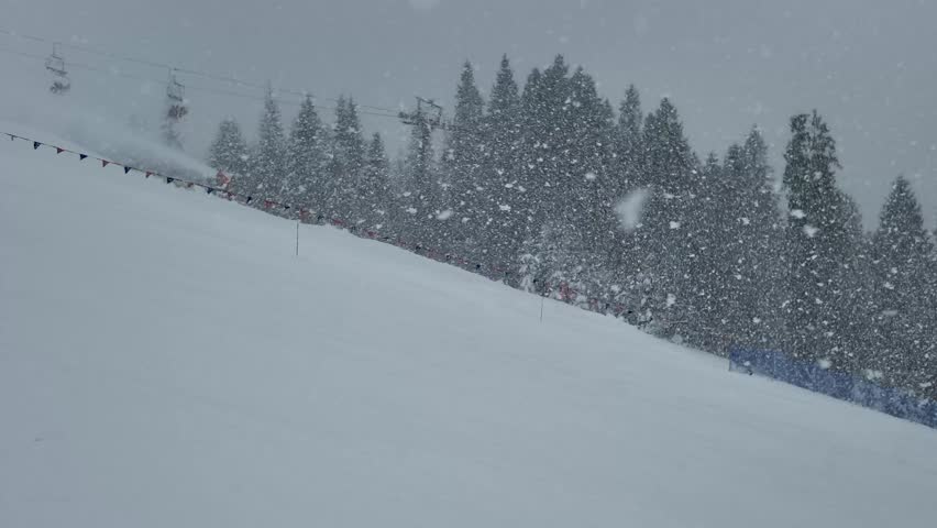 Snowboarder Riding Down Snowy Mountain Slope