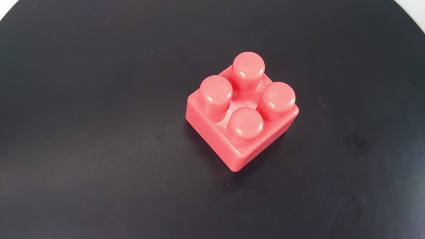 red plastic building blocks scattered on a textured surface