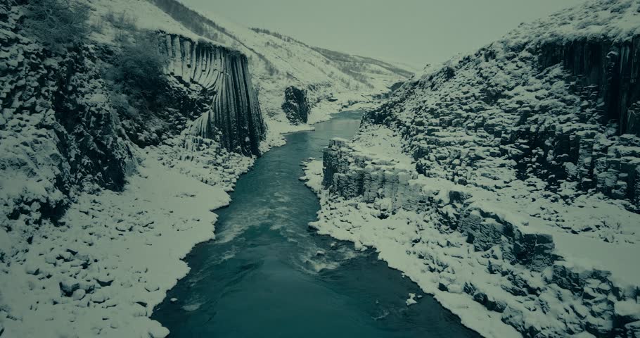 Cinematic Aerial View of Frozen River Canyon in Winter Snow