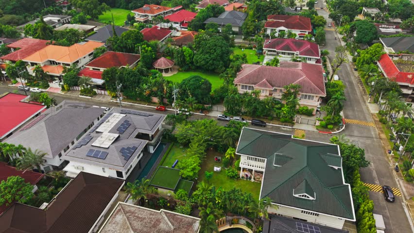 Cinematic aerial over quiet gated streets with moving cars, Ugong norte, Manila