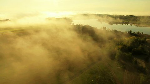Aerial View. Flying over the beautiful river in clouds . Aerial camera shot. Sunrise. Landscape panorama. Altai, Siberia.