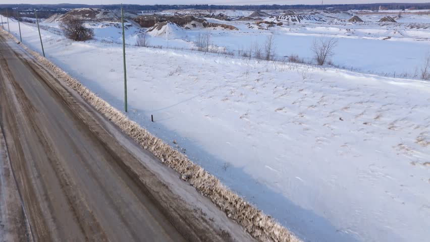 Gravel pit and aggregate stockpiles in snowy Ontario landscape near Toronto Aerial