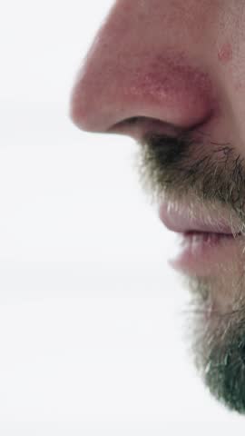 Close-up man drinking alcohol from glass, concept of addiction. Vertical video.