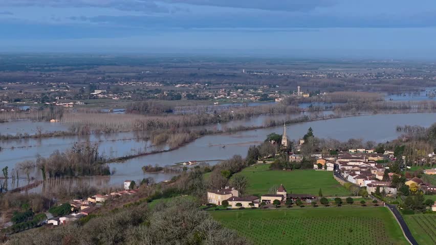Aerial view of floodwaters submerge a landscape of vineyards and a lone building, creating a scene of devastation, Flooded field, Sainte-Croix-du-Mont, Gironde, France.