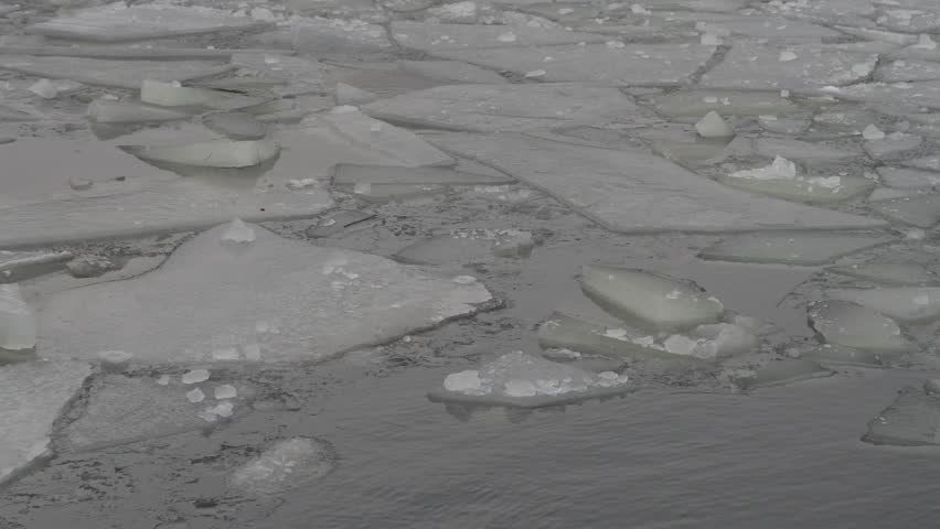 broken ice floes in the water with slight waves