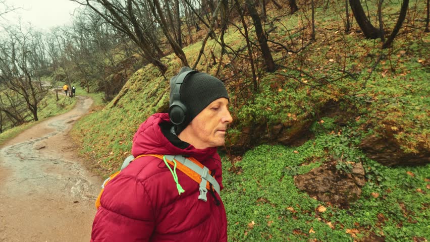 Calm walk of a 50+ year old man in the quiet, foggy and rainy woodland for emotional balance and zen.