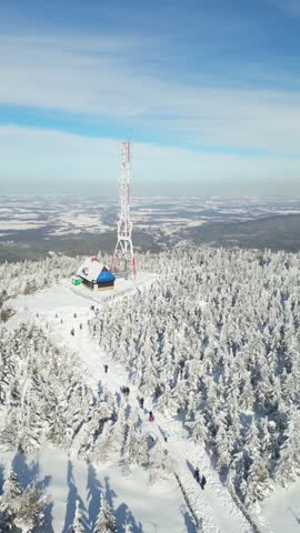 Aerial view of a communication tower and mountain cabin on a snowy peak. Świeradow-Zdrój, Poland.