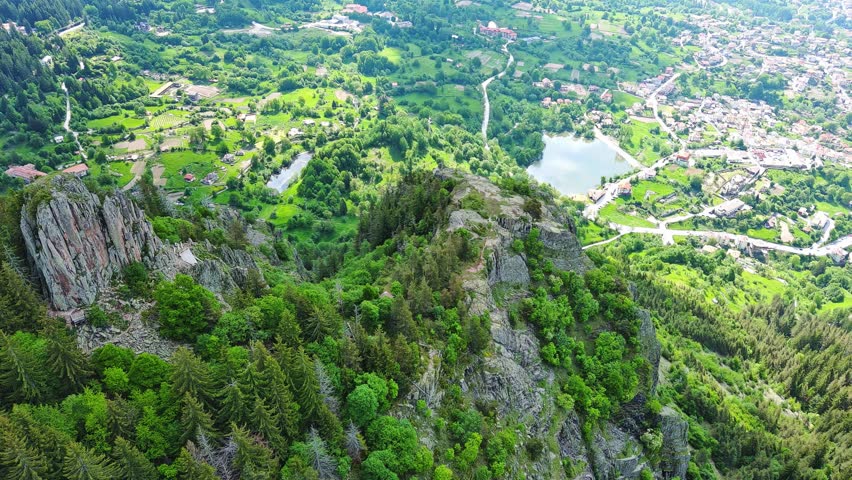 View from rock to town of Smolyan with meadows for cattle walking and houses between mountain range of Rhodope Mountains
