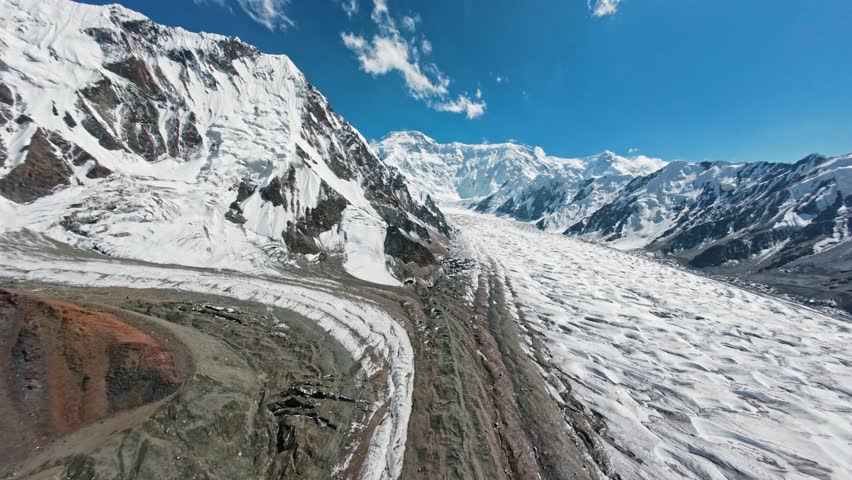Flight among mountains and glaciers to the Victory Peak. Tian Shan. Kyrgyzstan. 4K